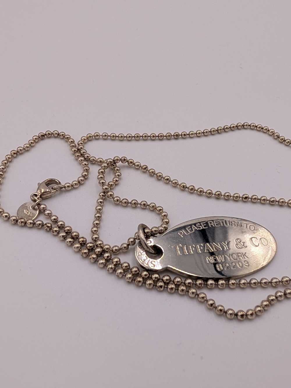 Tiffany & Co. polished silver oval tag on beaded chain
